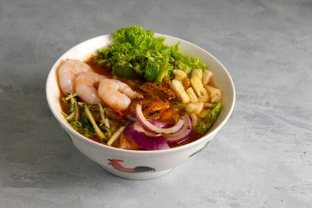Penang Laksa Noodle Soup with slate backgroundの写真素材