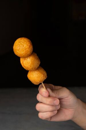 hand holding fish ball with dark backgroundの写真素材