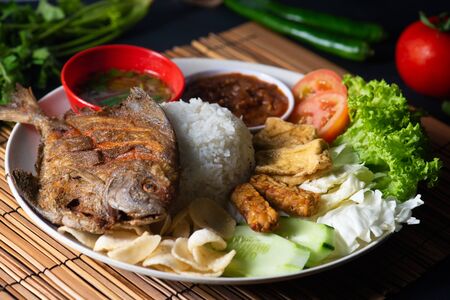 traditional fried pomfret fish with rice , sambal , vegables and mixed dishの写真素材