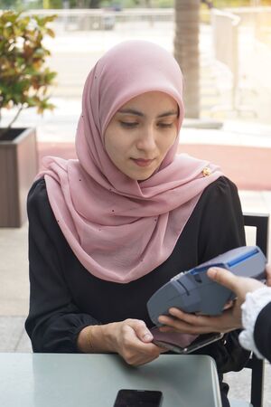 malay business woman paying with credit cardの写真素材
