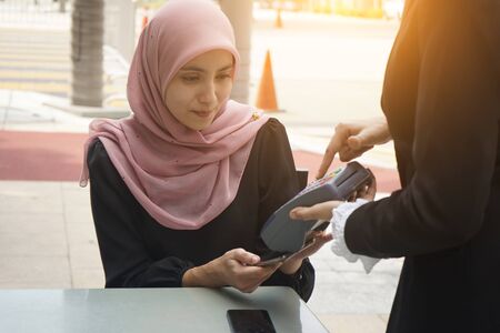 malay business woman paying with credit cardの写真素材