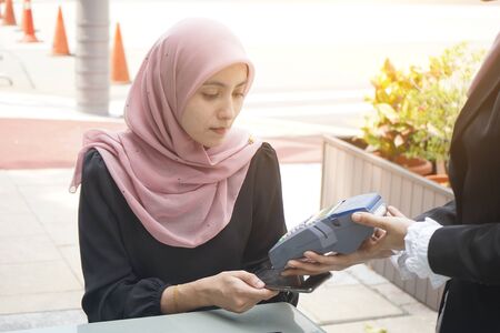 malay business woman paying with credit cardの写真素材
