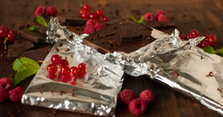 Delicious still life with juicy berries of red currants, raspberries, mint leaves and tiled...