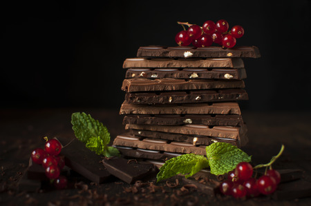 Delicious still life with juicy berries of red currants,  mint leaves and tiled chocolate.の写真素材
