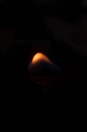 Flame of a candle on a black background.の写真素材
