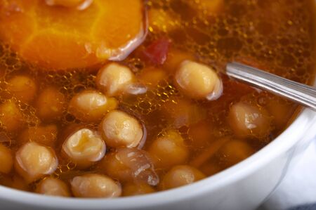 Soup with chicken, peas, tomato and sliced carrots. Tasty hot soup.の写真素材