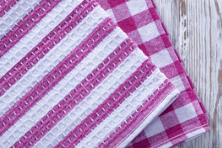 A stack of towels and napkins lying on the table. Clean kitchen towels, hand wipes lying on the table. Order in the kitchen. Colored napkins, towels.の写真素材