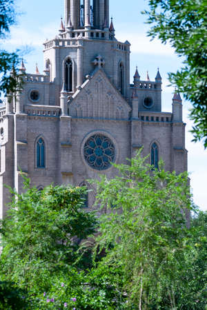 The Catholic Church in Tashkent in frame of greenery. Architectural building of the Church. Roman Catholic Temple of the Sacred Heart of Jesus. June 17, 2020, Uzbekistan, Tashkent city.のeditorial素材