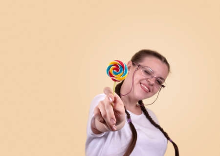 Smiling girl holding a lollipop. Sweets day. The girl is in a good mood.の写真素材