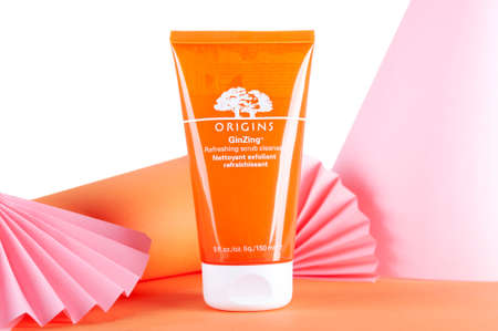 Scrub in an orange tube from ORIGINS. Background of pink and orange shapes.のeditorial素材