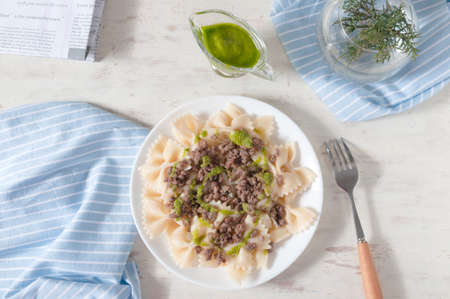 Delicious farfalle with freshly made pesto and minced meat.の写真素材