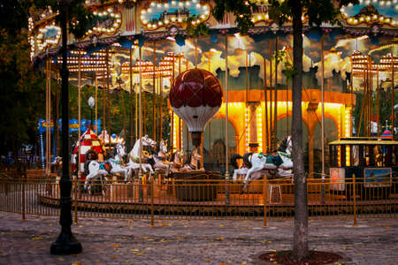 Children's carousel with horses. Evening park with carousel.のeditorial素材