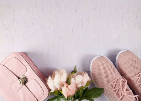 Things are laid out on a lilac, wooden background. A small pink handbag and light summer shoes. Layout on the table.の写真素材