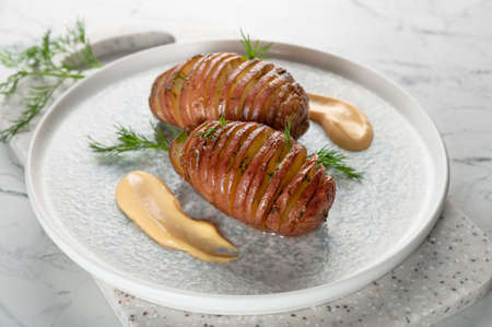 Baked potatoes served with herbs and sauce.の写真素材