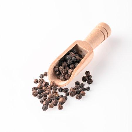 Peppercorns lie in a wooden scoop. Aromatic pepper used for cooking. Cooking spice.の写真素材