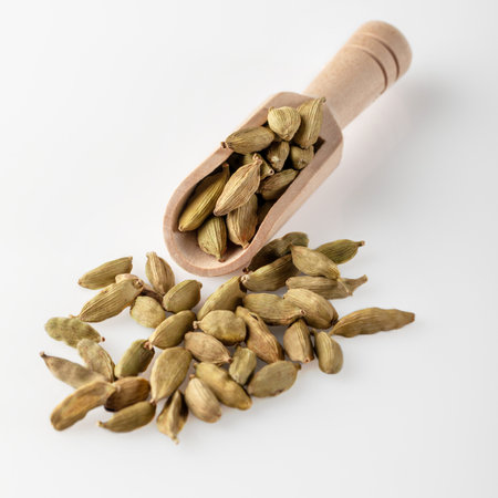 Cardamom seeds lie in a wooden scoop. Cardamom seeds used for making desserts and dishes. Cooking spice.の写真素材