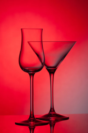 Empty glass wine glass on a red background. Wine glass for a drink on a red background. Dark silhouette of a glass.の写真素材