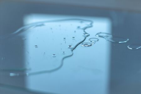 Liquid transparent gel or serum with oxigen bubbles on a glass surface. Hyaluronic acid or serum concept. Beauty and spa project. copyspace for text. の写真素材