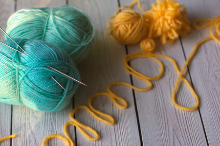 knitting yarn, needles, skeins of yarn. spring colors for knitting. turquoise and yellow yarn.