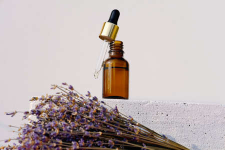 floral perfume bottle with white and pink flowers on white wooden tray. unbranded perfum for flowers fragrance presentation. scents of nature. top view, flat lay, selective focus.の写真素材