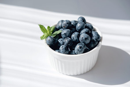 fresh Blueberry in a white bowl. antioxidant organic superfood concept for healthy eating and nutrition. bluberries under sunlight. meal for heart healthの写真素材