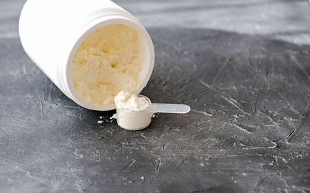 Collagen or protein in powder on gray background. protein powder for making whey drink or collagen cocktail.の写真素材