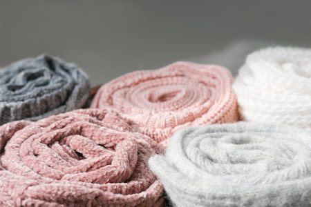 rolled knitted sweaters in grey and pink tones.