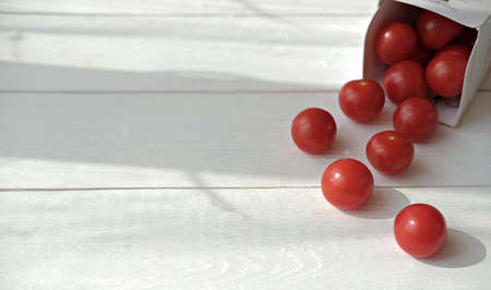cherry tomatoes scattering on table. fresh salad ingredient. spring and summer vitamin food. low carb diet meal. kids foos for peaky eaters.の写真素材