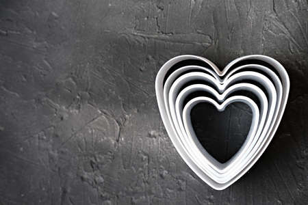 cookie cutters on gray background. heart shaped cookie cutters for baking. home baking concept. baking for family. love concept.の写真素材