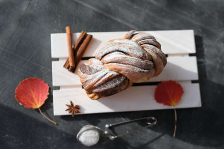 artisan sourdough cinnamon swirl bread on wooden rack. top view of autumn traditional sweet loaf bread with cinnamon and powdered sugar. spicy fresh baked bread. fall season pastry.の写真素材