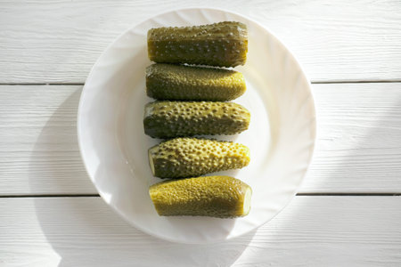 fermented cucumbers, five pickled marinated cucumbers on a plate. healthy vegan snack full of...