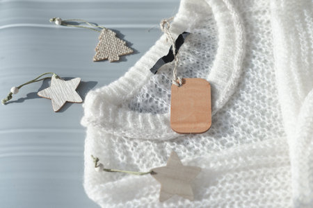 white knitted pullover with wooden tag mockup and wooden christmas tree. template for holiday sale...