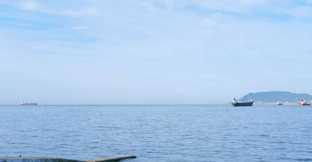sea bay view. ships on a horizon. calm and peaceful sea. copy space for text. cloudy weather.の写真素材