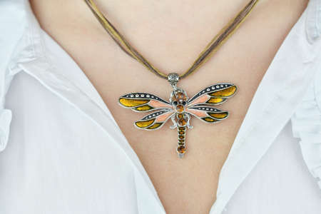 young woman neck with butterfly pendant made of enamel and metal with decorative stones .. trendy acsessories for holidays. present or gift for young girl or woman. beautiful necklace.の写真素材