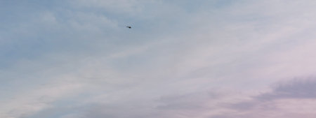 blue and pink clouds on the sky. helicopter flying far. transportation concept. medical aviation....