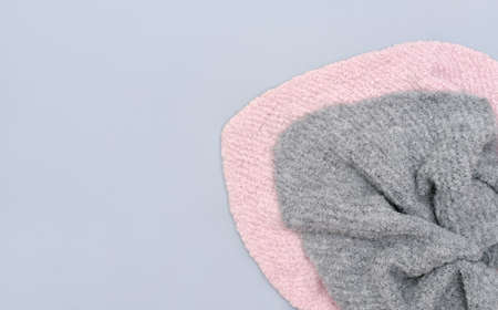 hand made girl baktus scarves on gray background. top view. winter outfit ideas. trendy warm scarves in pink and gray colors.の写真素材