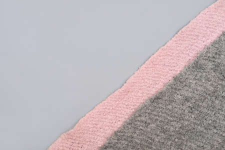 abstract background for knitting and needlework hobby projects. pink and gray knitted fabric, handmade scarf for cold season. textured winter acsessories for kids. copy spaceの写真素材