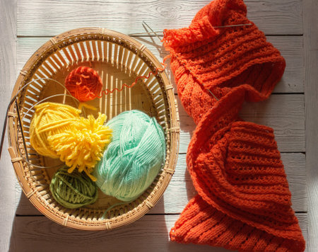 knitting yarn, needles, skeins of yarn. spring colors for knitting. orange, green and yellow yarn in...