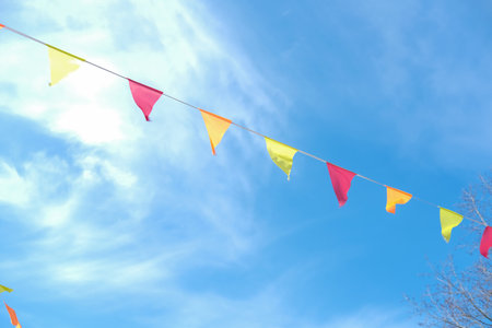 colorful bunting party flags over blue skyの写真素材