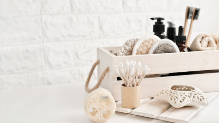 set of spa products for skin care in wooden box. brown bottles for beauty and relax. Scented candle and natural exfoliating washcloth and reusable sponges. copy space. biodegradable tools.の写真素材