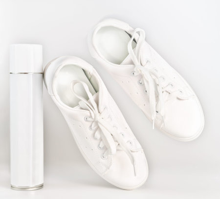 shoe protection spray. white sneackers and unbranded white spray tin can. waterproof treatment for...