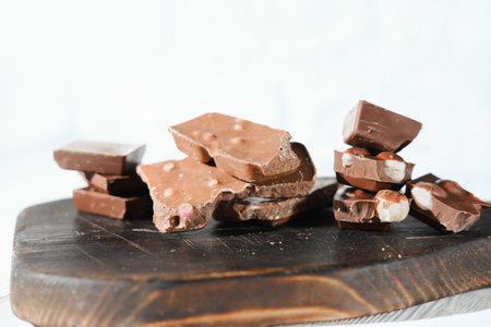 various types of chocolate on a cutting board. dark and milk chocolate with berries and nuts. tasty...