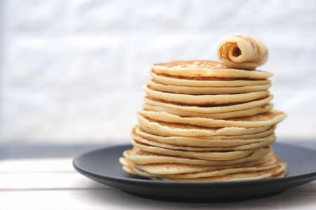 stack of classic american pancakes on a wooden rack. traditional family breakfast. comforting pancakes. front view. good morning concept.の写真素材