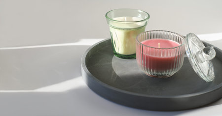 scented candles on a concrete tray. fragrances for cozy home. soy candles in glass. comfort in...