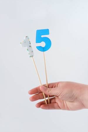 number 15 shaped lolipops in teenager's hand. teenager birthday. candies made for anniversary decor....