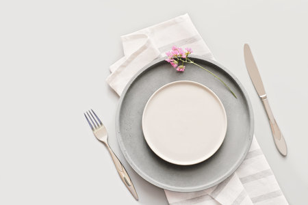empty gray plates on a table with fork and knife. spring menu concept. trendy nordic minimal style...