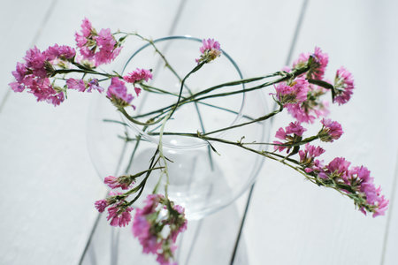 delicate pink flowers in round glass vase. spring aesthetic. selective focus. minimal style home...