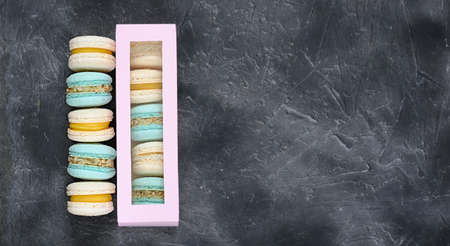 macaroons in pastel blue and beige colors on grey background. a box of cookies. french sweet dessert made of almond flour. homemade macaron. copy spaceの写真素材
