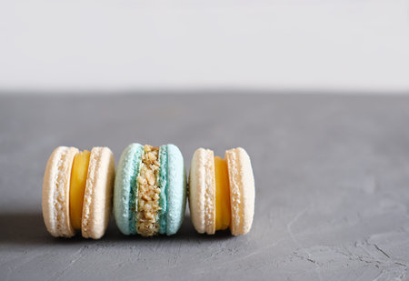 macaroons in pastel blue and beige colors on gray background. french sweet dessert made of almond...