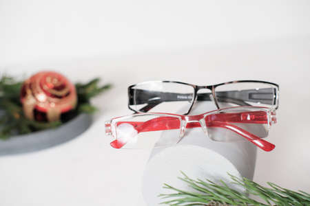 pair of eyeglasses on a grey geometric podium. christmas decor. eye sight, vision concept. optic store christmas saleの写真素材